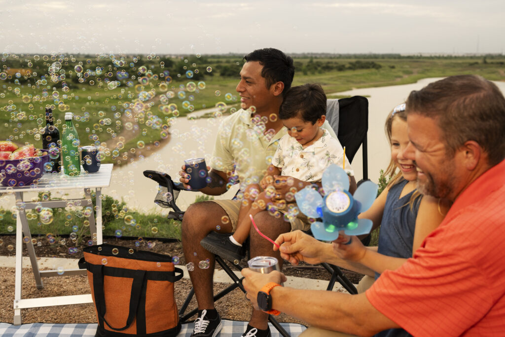 father and daughter blowing bubbles at an event showing the benefits of master-planned communities