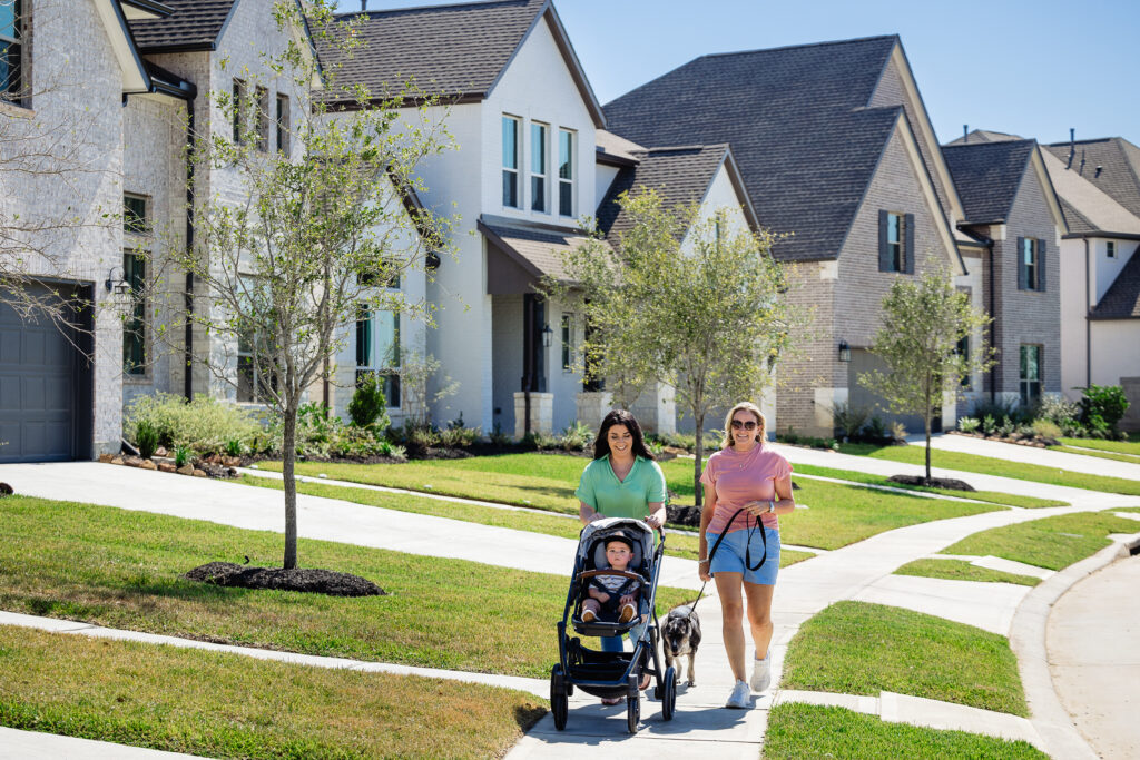 friends walking with baby in stroller and dog enjoying the benefits of energy-efficient homes